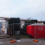 skip and fencing outside gutted hall