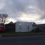 the roof of the church hall gone, beneath a cloudy sky